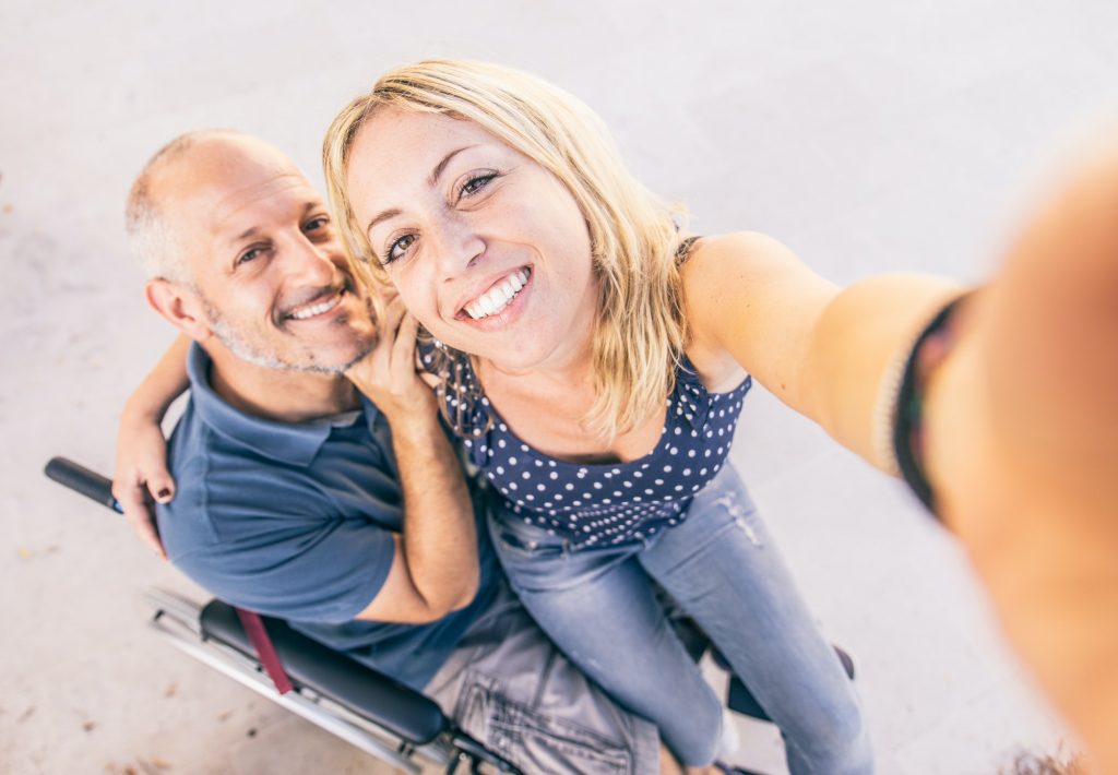 Man on wheel chair and his assistant