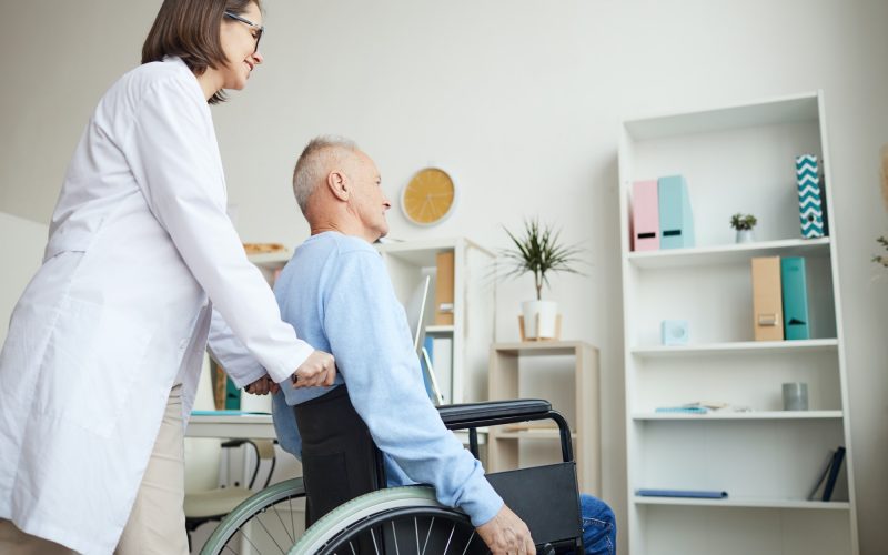 Nurse Helping Disabled Old Man